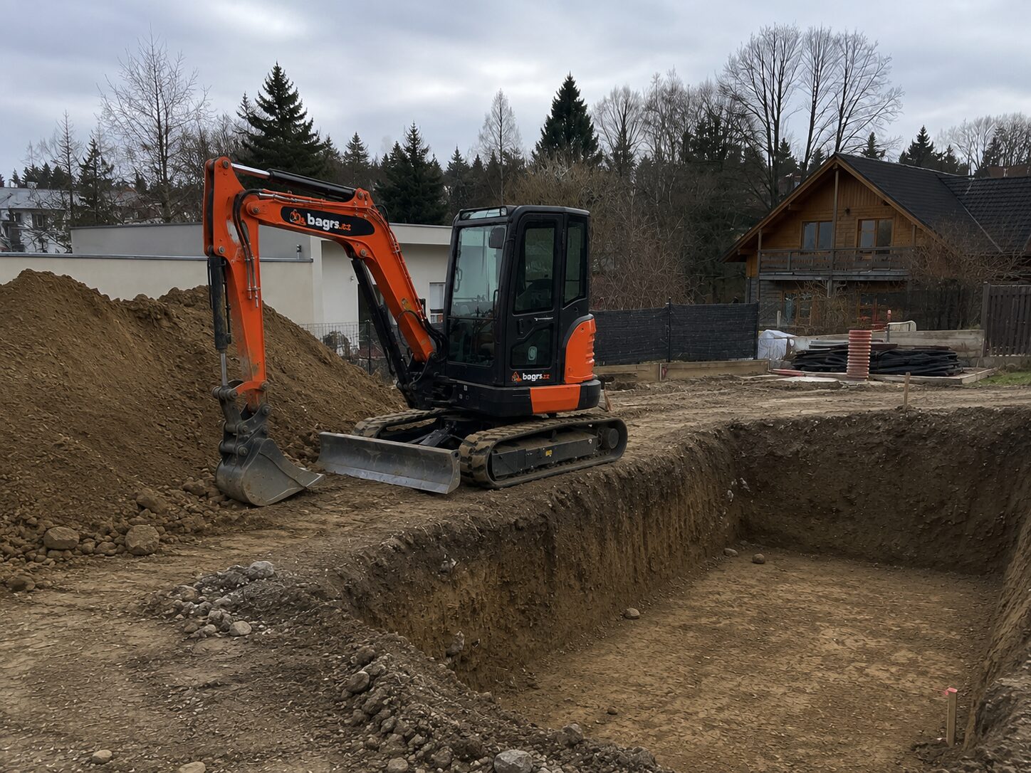Příprava základových pasů a stavební jámy bagrem